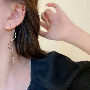 Detailed close-up view of elegant silver long tassel spiral threader earrings worn by a model