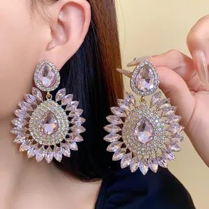 Detailed close-up view of oversized rhinestone floral drop earrings in elegant soft pink