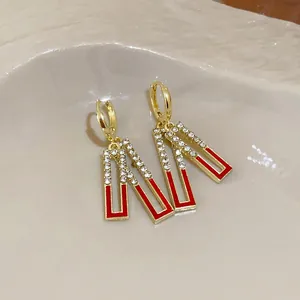 Elegant gold geometric drop earrings with red enamel and sparkling white rhinestones