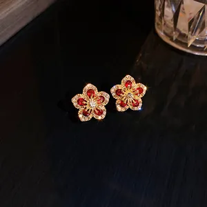 Close-up of sparkling red crystal flower earrings in gold-tone setting