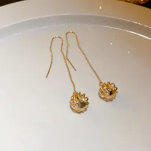 Detailed view of elegant gold long tassel ear threader earrings with crystal balls.