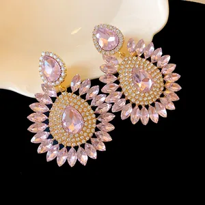 Detailed view of oversized pink crystal floral drop earrings with teardrop center