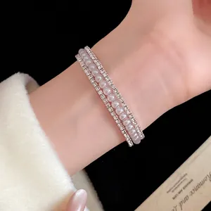 Elegante bracciale a tre strati con perle e strass luccicanti sulla mano di una modella