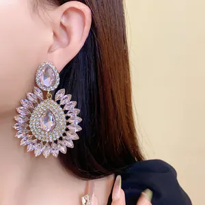 Close-up of oversized pink crystal flower earrings on an Asian model's ear