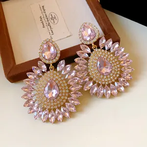 Close-up detail of oversized pink rhinestone flower drop earrings with waterdrop crystals