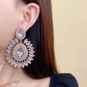 Exquisite close-up of large pink teardrop crystal flower earrings on a model's ear