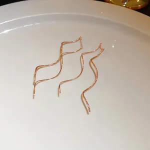 Close-up of rose gold wavy ear threads showing delicate diamond-cut details