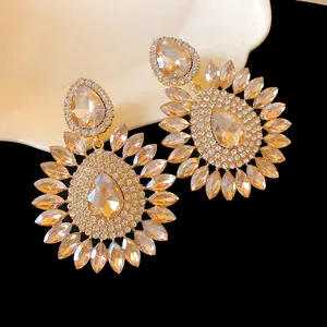Close-up showing the intricate champagne crystal arrangement on these gold earrings
