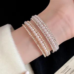 Dettaglio ravvicinato di un elegante set di braccialetti multistrato con perle e strass