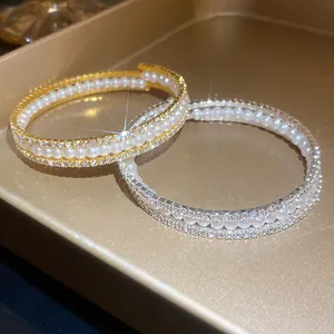 Dettaglio ravvicinato di bracciali a tre strati con perle eleganti e cristalli scintillanti.