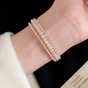 Vista dettagliata di un elegante bracciale a tre strati con perle e strass al polso