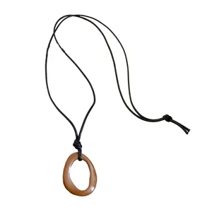 Minimalist retro irregular geometric necklace with brown oil-dripped pendant on black cord.