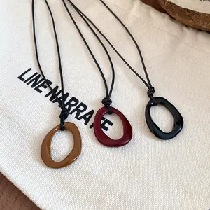 Retro irregular geometric enamel necklace with adjustable black cord in three colors.