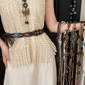 Detail view of bohemian woven waist chains with turquoise beads and butterfly charms