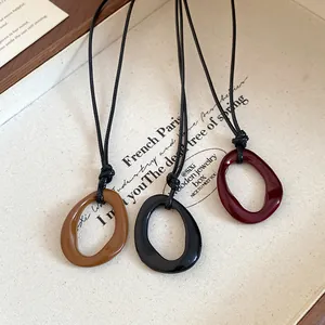 Detail view of three vintage irregular geometric necklaces in brown, black, and red