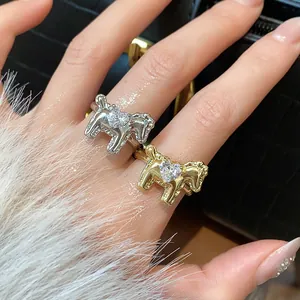 Detailed view of horse-shaped rings with heart-shaped zircon stones in gold and silver.