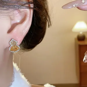 Primo piano di orecchini vintage a forma di zucca in argento con zirconi arancioni