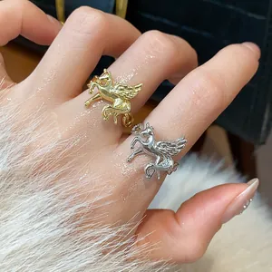 Exquisite detail view of gold and silver Pegasus winged horse open rings worn on fingers