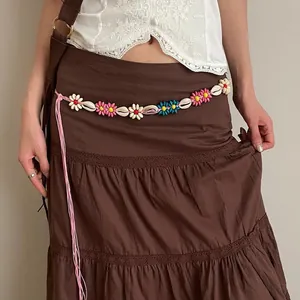 Bohemian braided waist chain with colorful flowers and shell details on a brown skirt