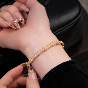Gros plan détaillé d'un bracelet doré avec oxydes de zirconium et maillons croisés.