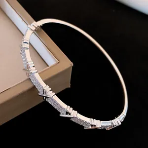Gros plan d'un jonc argenté élégant avec oxydes de zirconium et boucle croisée détaillée