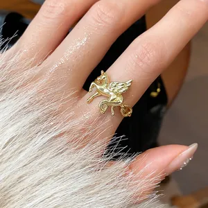 Detailed macro shot of a golden Pegasus open ring featuring intricate wing textures and shine