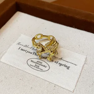 Close-up of elegant gold Pegasus open ring with chain band on a jewelry card.