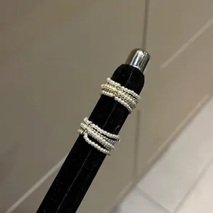 Nahaufnahme von eleganten mehrlagigen Perlenringen auf einem schwarzen Samtständer