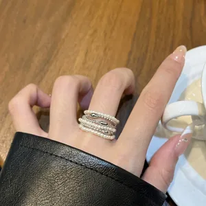 Elegante Detailaufnahme eines mehrlagigen Perlen- und Silberperlenrings am Finger