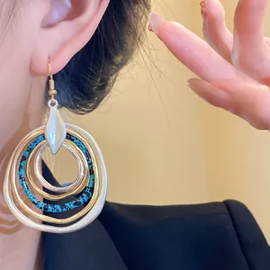 Close-up detail of irregular multi-layer circle earrings with blue speckled texture