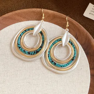Detail view of irregular multi-layered round dangle earrings with vintage splash patterns