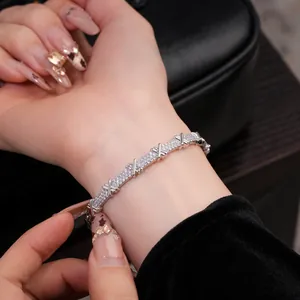 Gros plan d'un bracelet croisé en argent avec des pierres de zircone au poignet