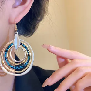 Close-up of retro multi-layer hoop earrings with blue speckled pattern on model