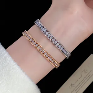Elegant close-up of gold and silver rhinestone wrapped chain bracelets worn on a wrist.