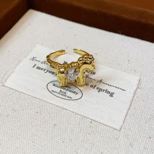 Close-up detail of a gold-plated pony open ring featuring a sparkling heart zircon center
