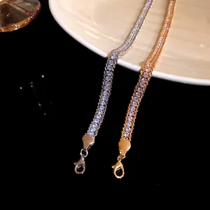 Detailed macro view of gold and silver rhinestone wrapped chain bracelets with lobster clasps