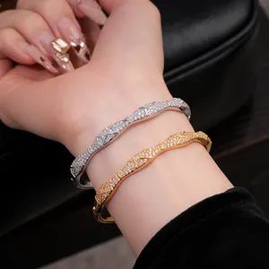 Gros plan de bracelets croisés plaqués or et argent avec des zircons brillants