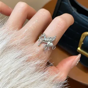 Detailed view of silver-tone Pegasus open ring with intricate wings on a finger