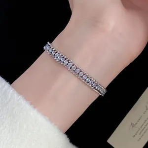Detailed macro view of a minimalist diamond-encrusted twisted chain bracelet on a female wrist