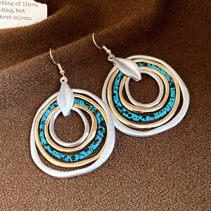 Detailed macro view of multi-layered irregular circle drop earrings with splatter pattern