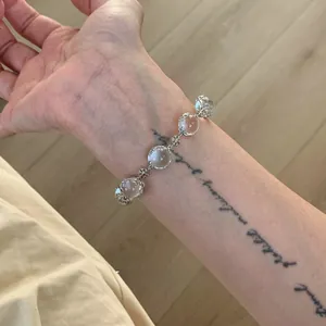 Detailed view of an elegant snowflake beaded bracelet worn on a wrist with minimalist design