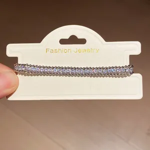 Detail view of a sparkling rhinestone wrap chain bracelet on a display card