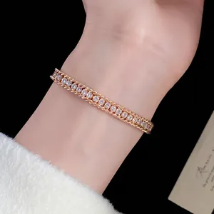 Close-up of an elegant gold chain bracelet with sparkling crystals on a woman's wrist