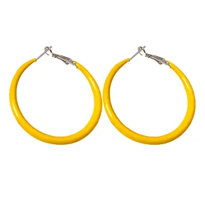 Vibrant yellow enamel hoop earrings with silver pins for a minimalist fashion look.