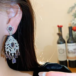 Dettaglio dell'orecchino a nappa in zircone stile corte vintage con pietre viola indossato