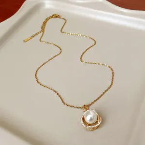 Dettaglio di un'elegante collana francese con perle e zirconi e pendente dorato chic.