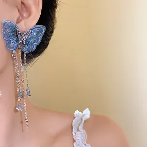 Vista dettagliata degli orecchini a farfalla blu ricamati con nappe e cristalli.