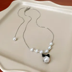 Dettaglio di una collana di perle in stile francese con un elegante ciondolo a fiocco nero