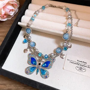Dettaglio di una collana con farfalla in cristallo blu in una scatola per gioielli