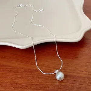 Dettaglio di una catena in argento con pendente a perla bianca rotonda in stile francese
